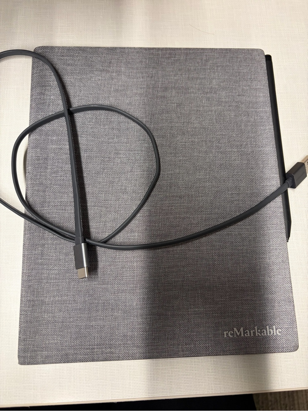 reMarkable 2 Tablet & gray cover with charging cable and stylus pen.